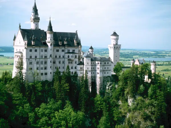 Ihr seht das Schloss Neuschwanstein in Bayern mit Landschaft im Sommer.