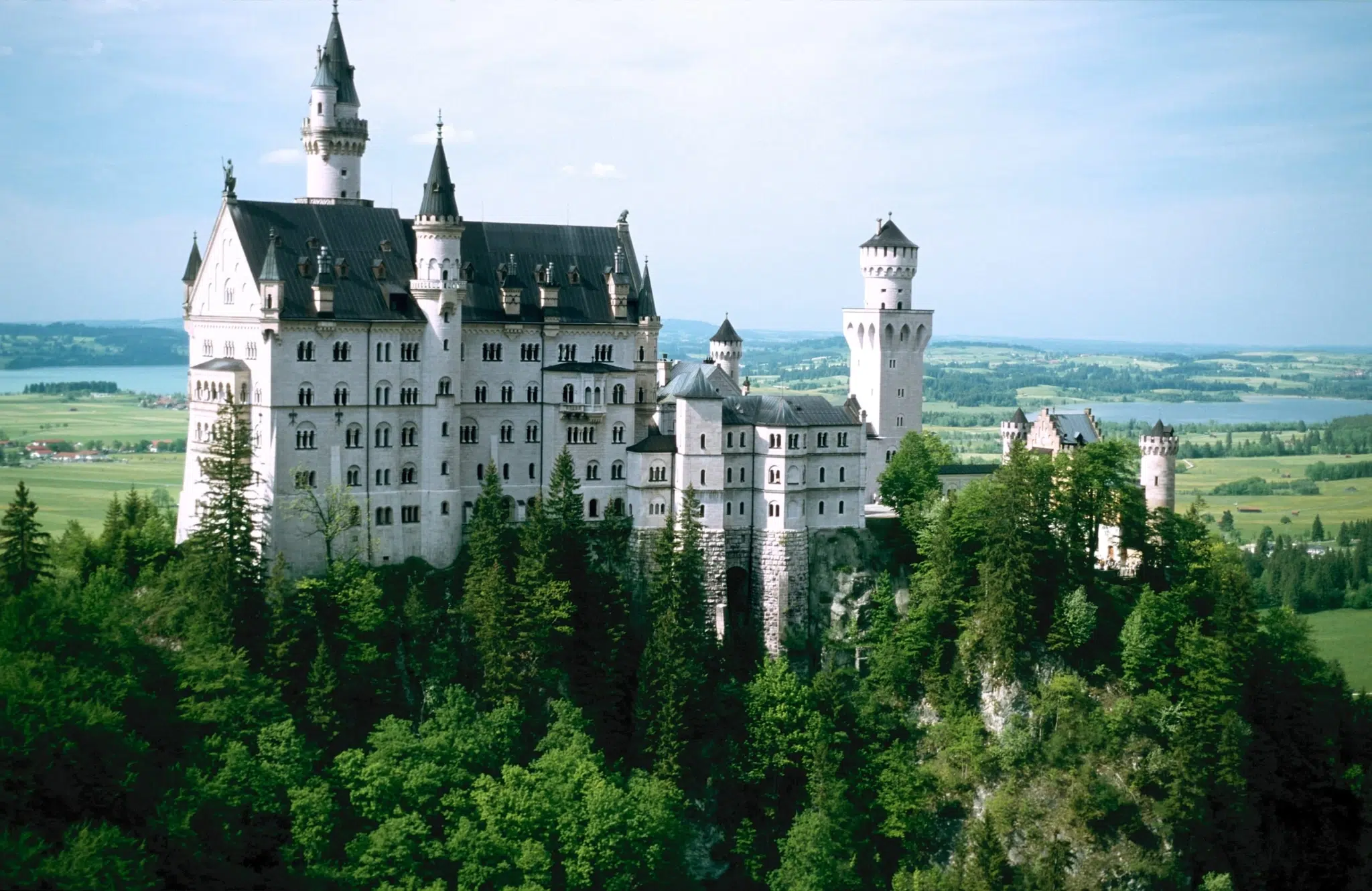 Schloss Neuschwanstein in Bayern mit Landschaft im Sommer.