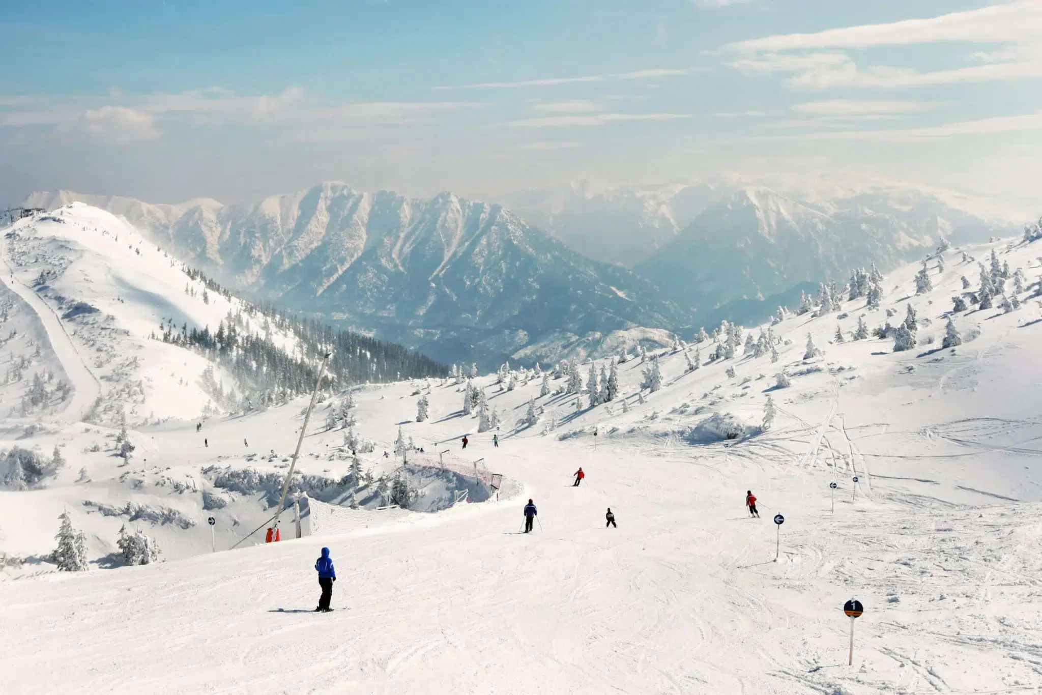 Skigebiet Hochkar im Mostviertel in Niederösterreich mit Skifahrern, die die Skipiste herunterfahren in der Nähe vom JUFA Hotel Hochkar. Der Ort für erfolgreiches Training in ungezwungener Atmosphäre für Vereine und Teams.