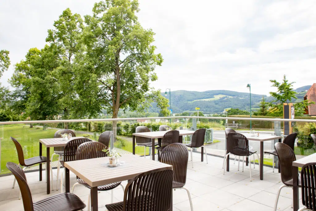 Ihr seht ein Bild von der Restaurantterasse mit Blick auf den Stubenbergsee im JUFA Hotel Garni Stubenberg.