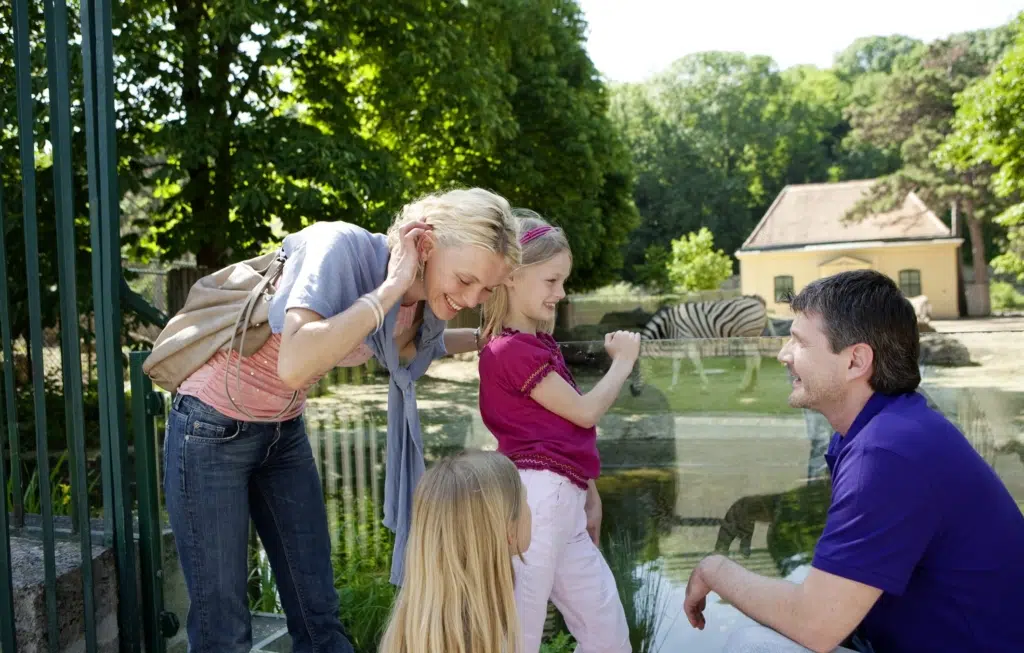 Familie beim Zoobesuch im Tiergarten Schönbrunn in Wien. JUFA Hotels bietet kinderfreundlichen und erlebnisreichen Urlaub für die ganze Familie.