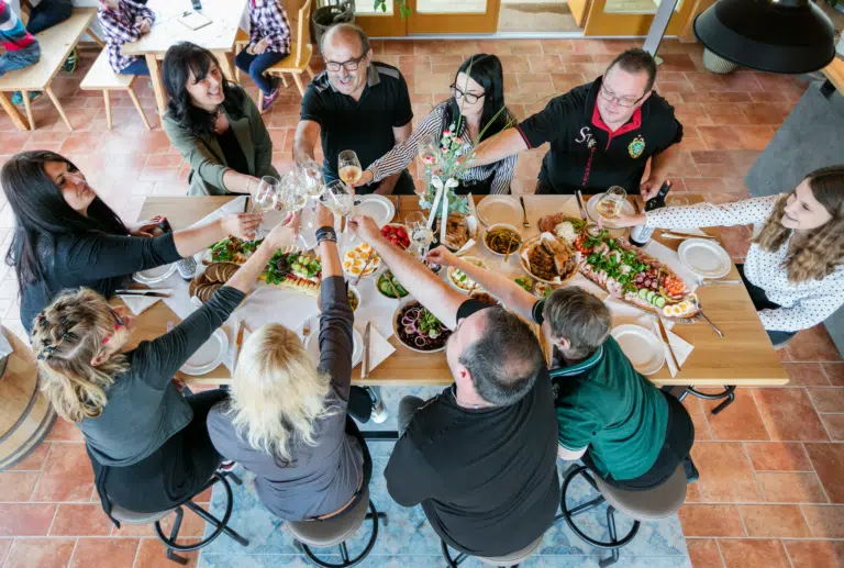 Ihr seht eine Tischrunde in der Vinothek im JUFA Hotel Tieschen – Bio-Landerlebnis. Der Ort für kinderfreundlichen und erlebnisreichen Urlaub für die ganze Familie.