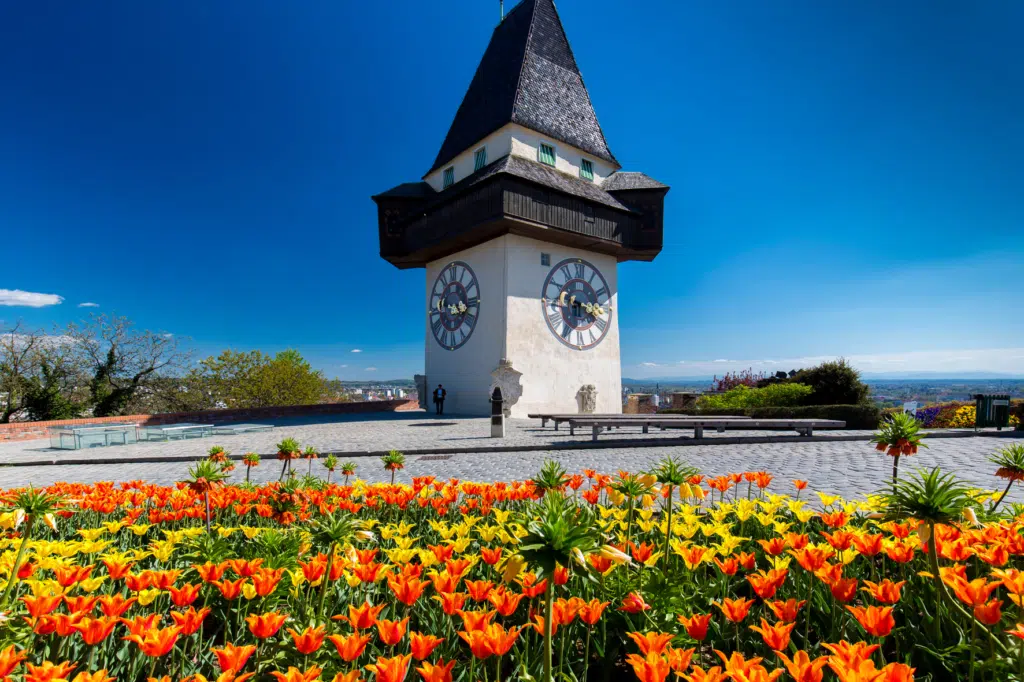 Sie sehen den Uhrturm in Graz im Frühling. JUFA Hotels bietet erholsamen Familienurlaub und einen unvergesslichen Winterurlaub