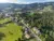 Ihr seht ein Panoramabild aus der Vogelperspektive vom Ort Stubenberg im Apfelland mit dem JUFA Hotel Garni Stubenberg, den umliegenden Wiesen und Wälder und den Hügeln der Oststeiermark.