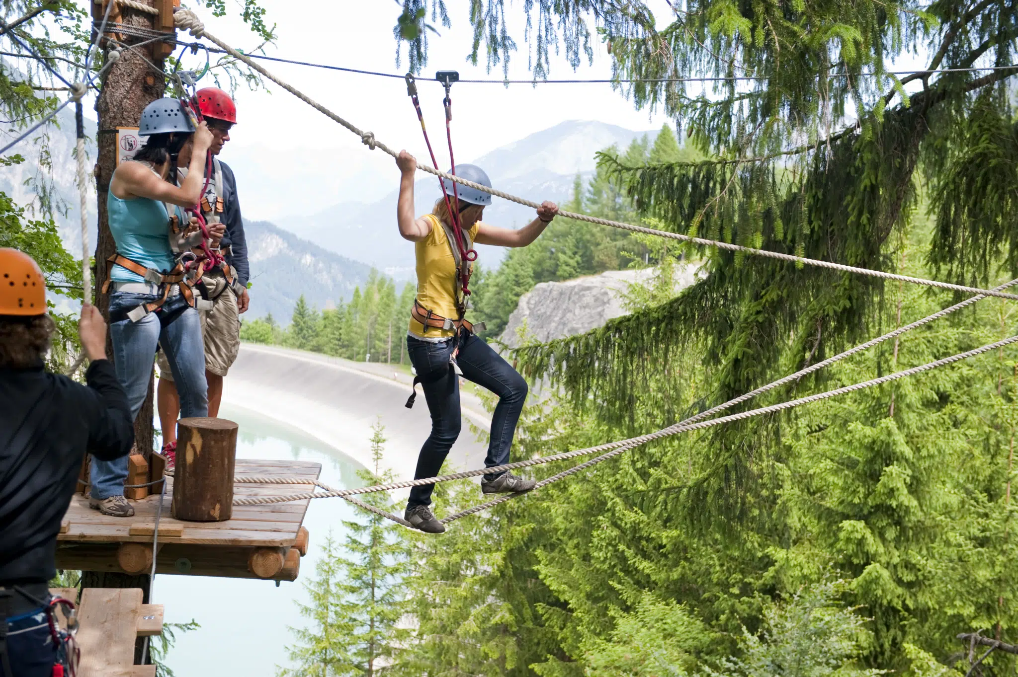 Erwachsene klettern im Waldseilpark-Golm im Montafon in der Nähe vom JUFA Hotel Montafon. Der Ort für kinderfreundlichen und erlebnisreichen Urlaub für die ganze Familie.