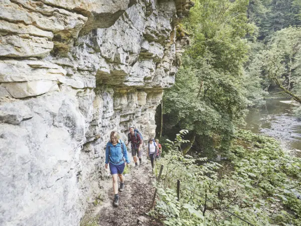 Ihr seht mehrere Personen beim Wandern entlang der Wutachschlucht im Schwarzwald.