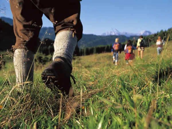 Ihr seht eine Gruppe von Erwachsenen beim Wandern im abwechslungsreichen Wandergebiet Weissensee in Kärnten.