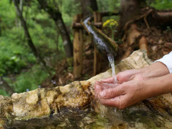 Ihr seht die Wasserquelle in den Nockbergen mit einem Wanderer.