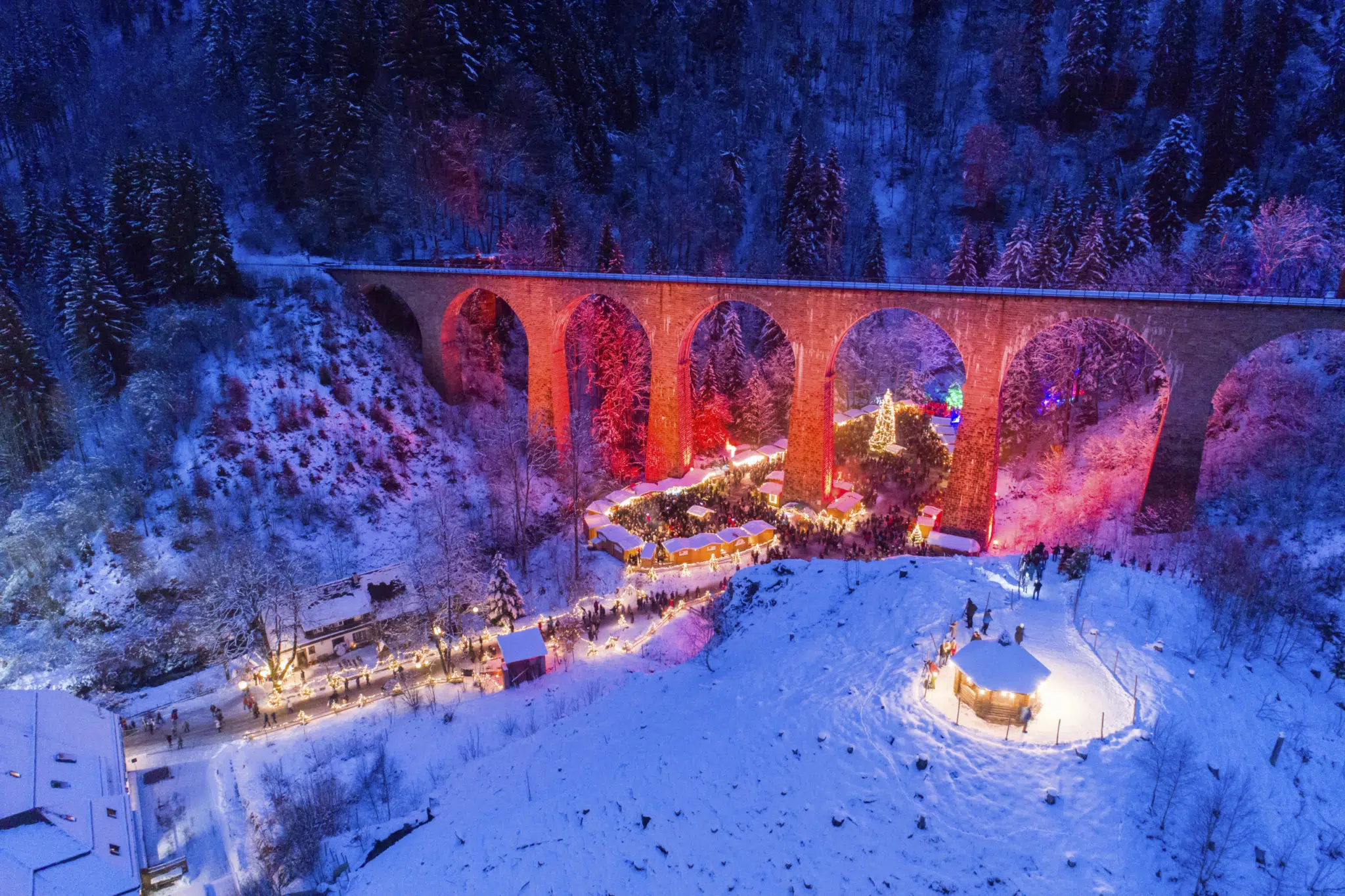 Ihr seht den Weihnachtsmarkt in der Ravennaschlucht unter der Brücke gelegen mit weihnachtlicher Beleuchtung.