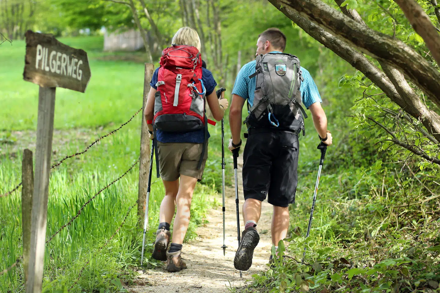 Ihr seht zwei Personen beim Wandern am Pilgerweg.