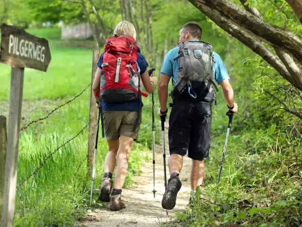 Ihr seht zwei Personen beim Wandern mit Wanderstöcken im Mariazellerland.