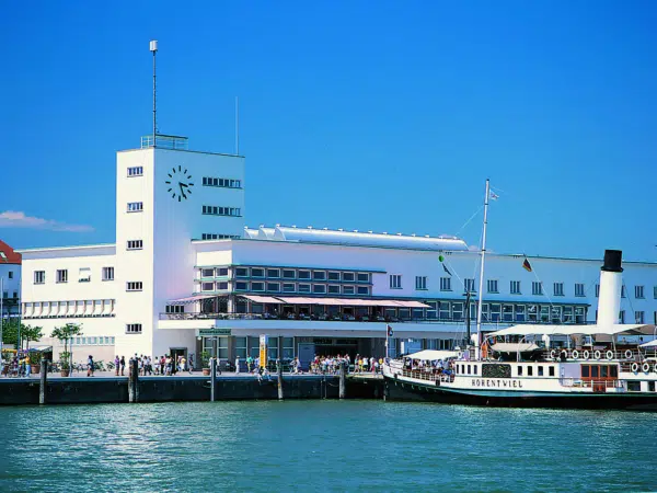 Ihr seht das Zeppelin Museum in Friedrichshafen am Bodensee mit einem Ausflugsboot. JUFA Hotels bietet kinderfreundlichen und erlebnisreichen Urlaub für die ganze Familie., Bodensee, boot, deutschland, freizeittipps, Friedrichshafen, highlights, menschen, museum, see, Wasser, zeppelin