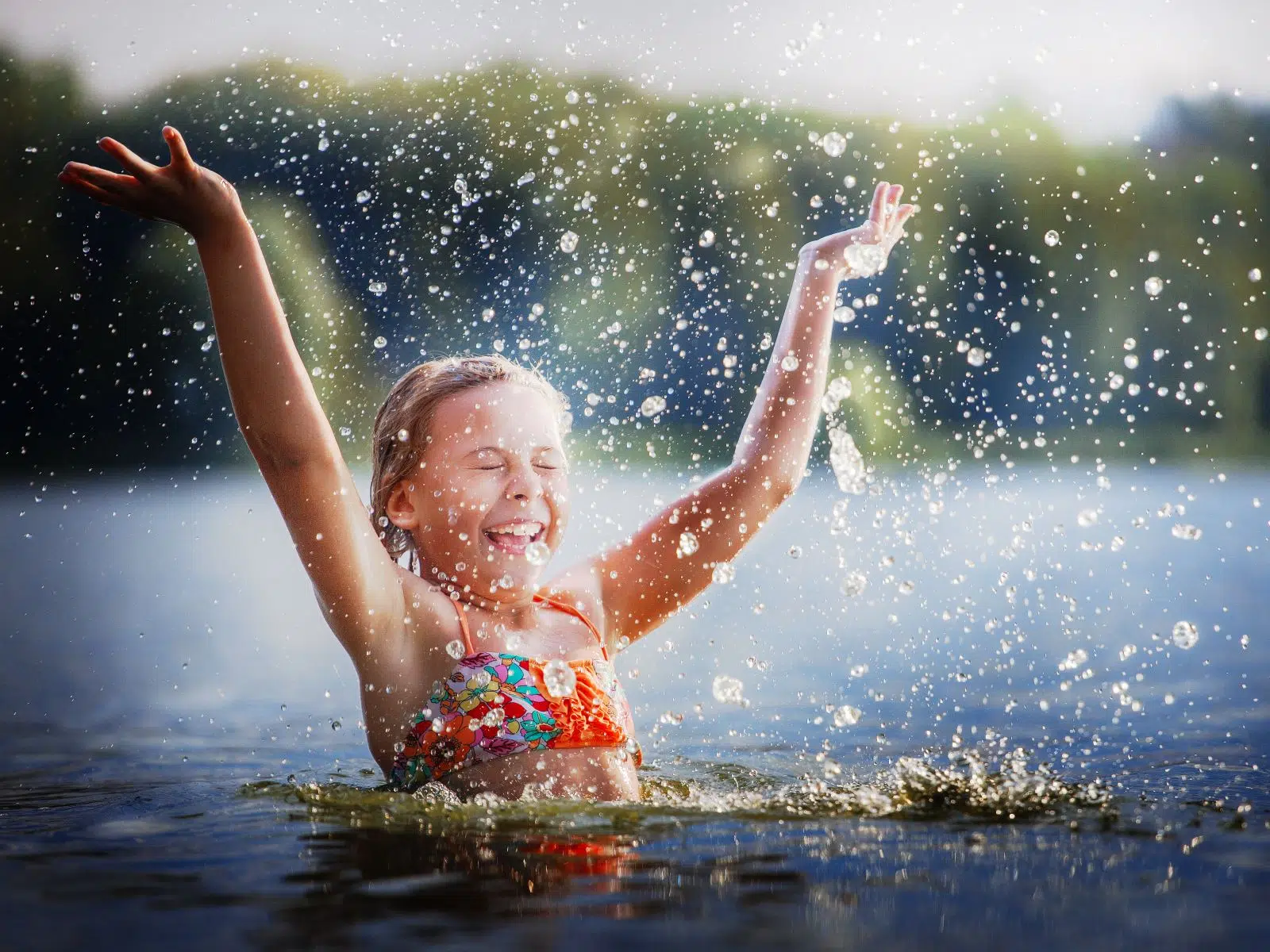 Ihr seht ein Kind im Wasser plantschen.