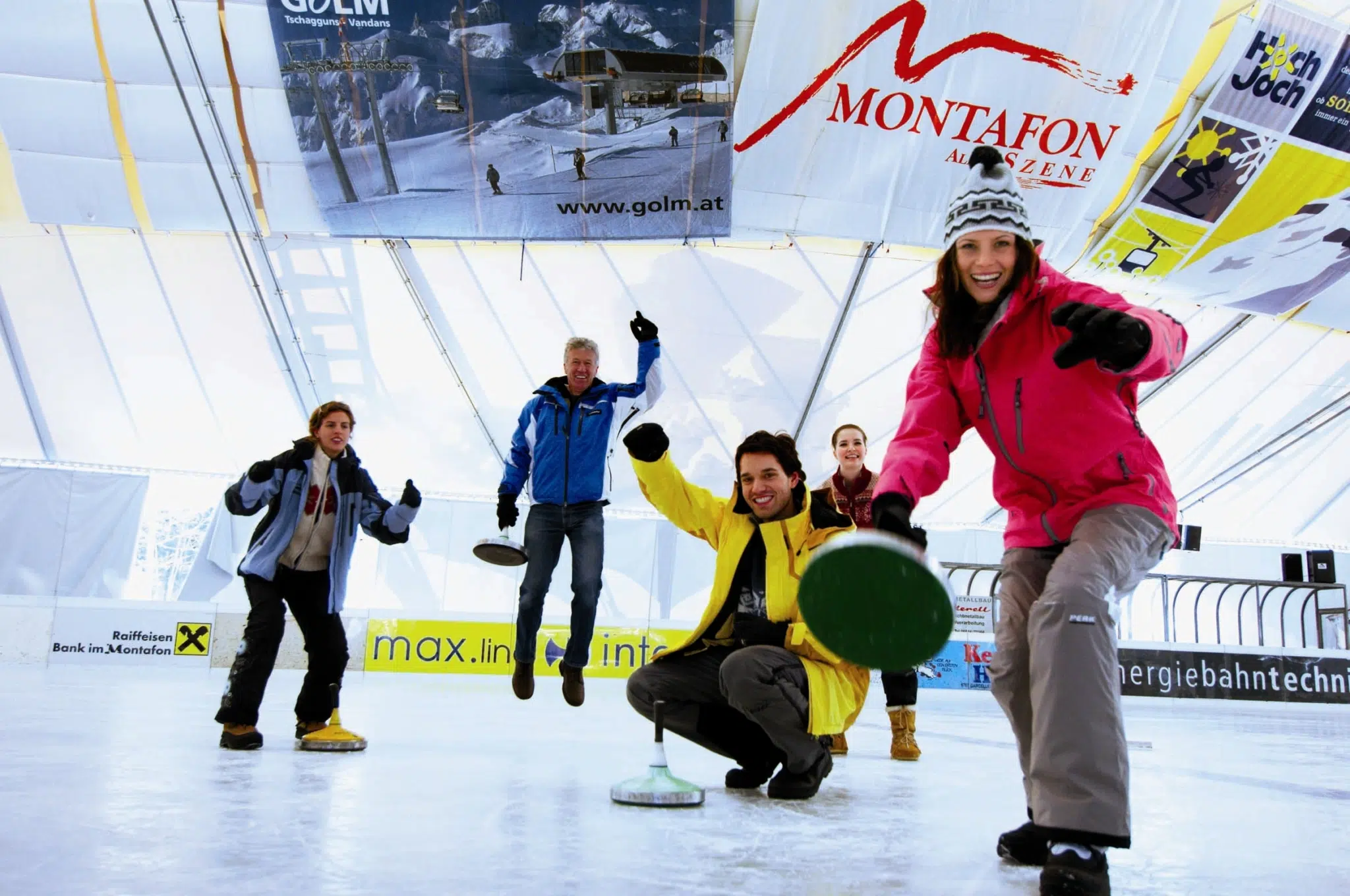 Ihr seht junge Menschen beim Eisstockschießen auf der Kunsteisbahn im Aktivpark in Montafon. Der Ort für erholsamen Familienurlaub und einen unvergesslichen Winterurlaub.