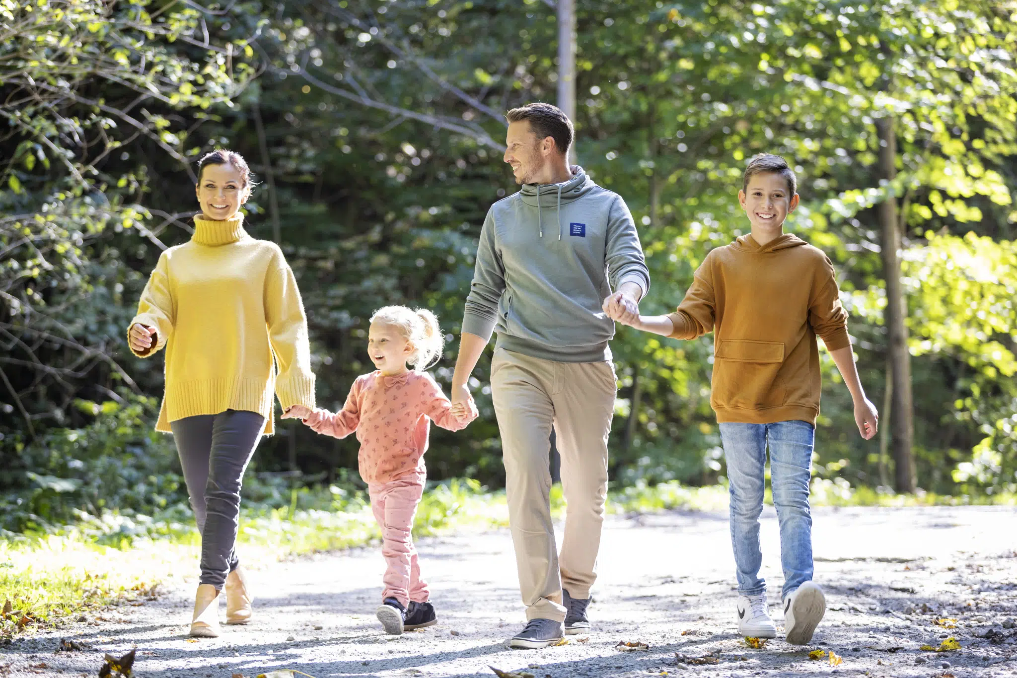 Familie bei Herbstspaziergang - Mama sieht in Kamera