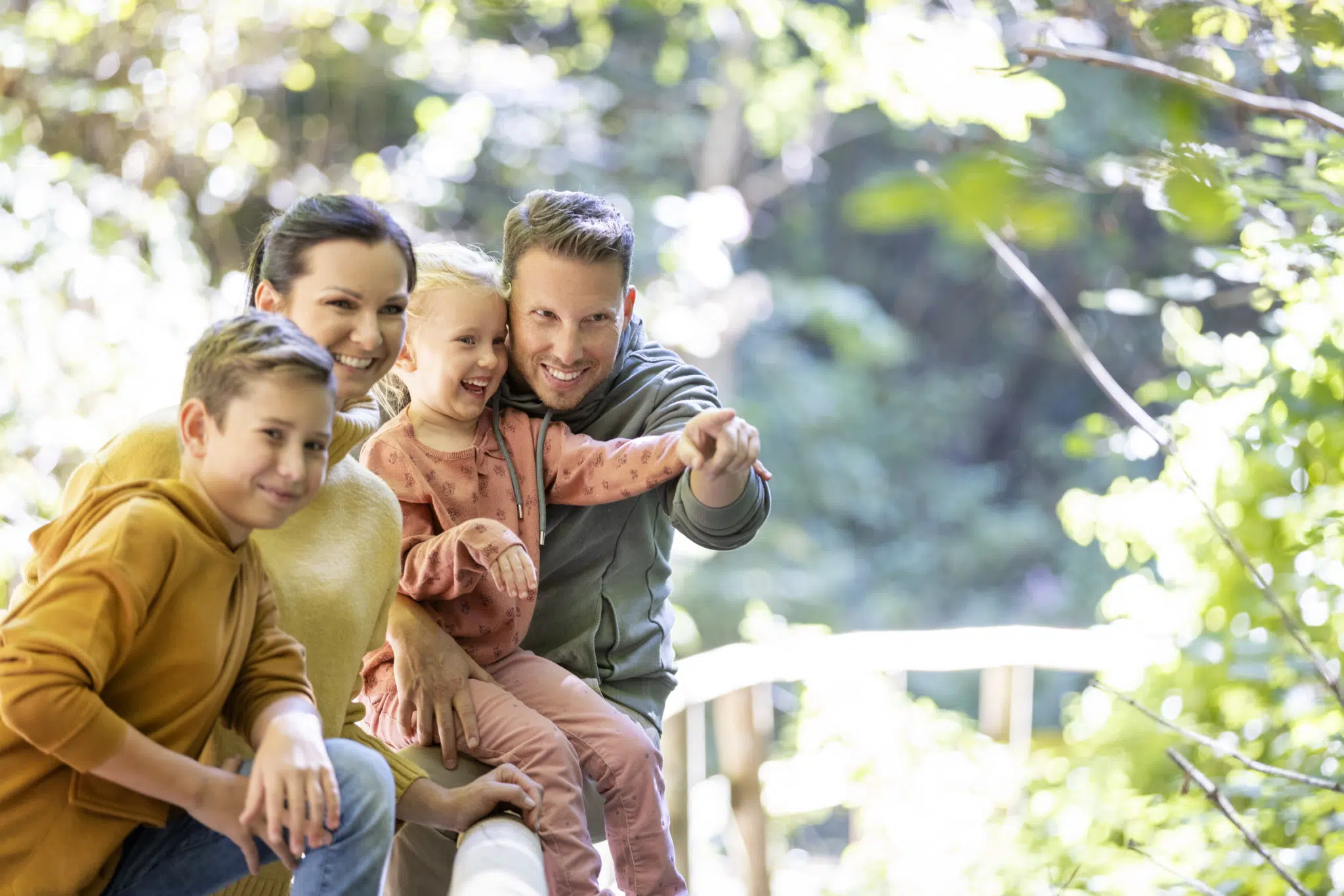 Ihr seht eine Familie, die gerade bei einem Herbstspaziergang pausiert und den Ausblick genießt.