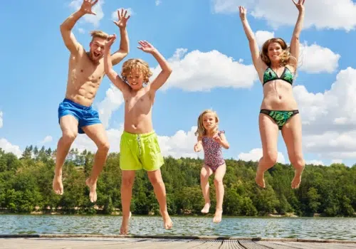 Ihr seht eine Familie in den See springen.