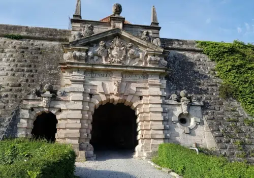 Ihr seht den Festungseingang vom JUFA Hotel Festung Rosenberg Kronach***s im Sommer. JUFA Hotels bietet kinderfreundlichen und erlebnisreichen Urlaub für die ganze Familie.