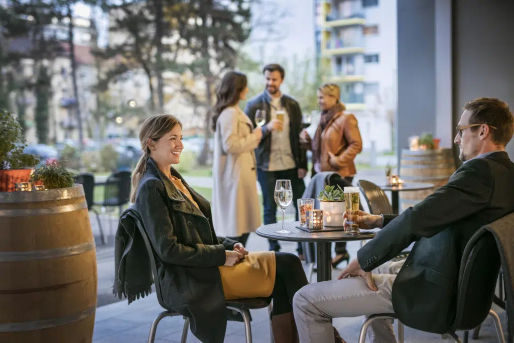 Sie sehen Gäste auf der Terrasse beim Afterwork im JUFA Hotel Graz City***.