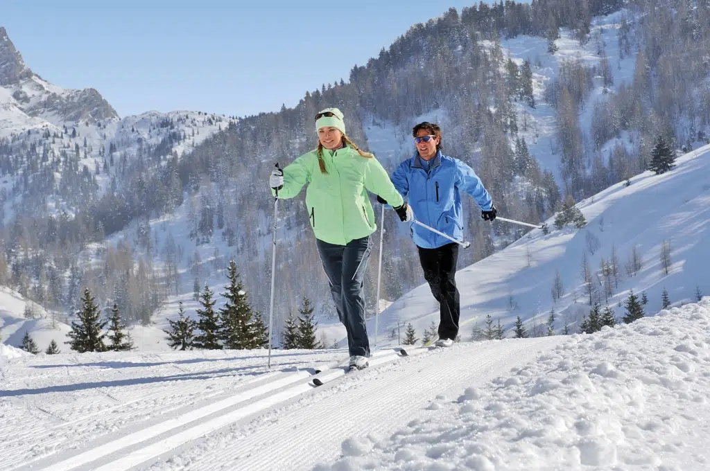 Ihr seht zwei Personen beim Langlaufen im Winter in der Urlaubsregion Pyhrn-Priel.