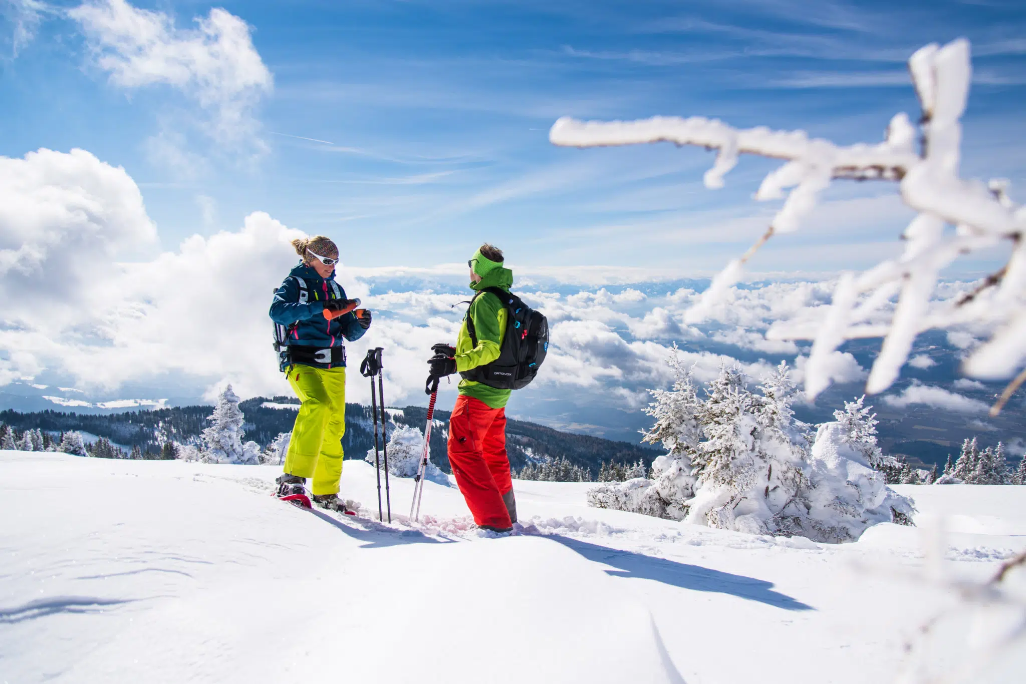 Ihr seht zwei Personen beim Skifahren im Winter im Lavanttal.