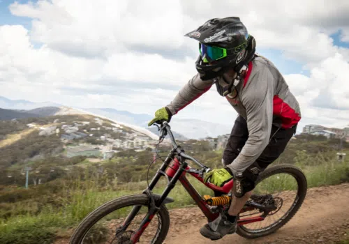 Ihr seht eine Person beim Mountainbiken im Sommer.