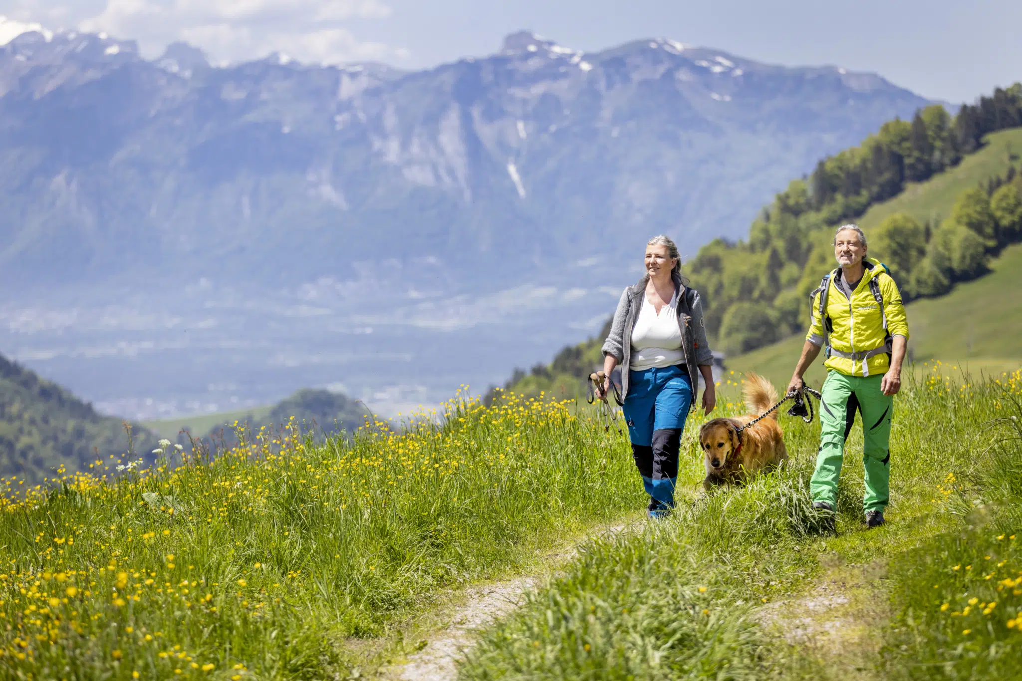 Paar mit Hund beim Wandern im Laternsertal im JUFA Hotel Laterns – Klangholzhus***. Der Ort für erholsamen Familienurlaub und einen unvergesslichen Winter- und Wanderurlaub.