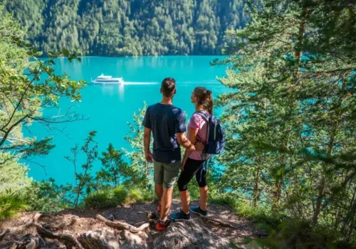 Ihr seht zwei Personen beim Wandern oberhalb des Weissensee in Kärnten.