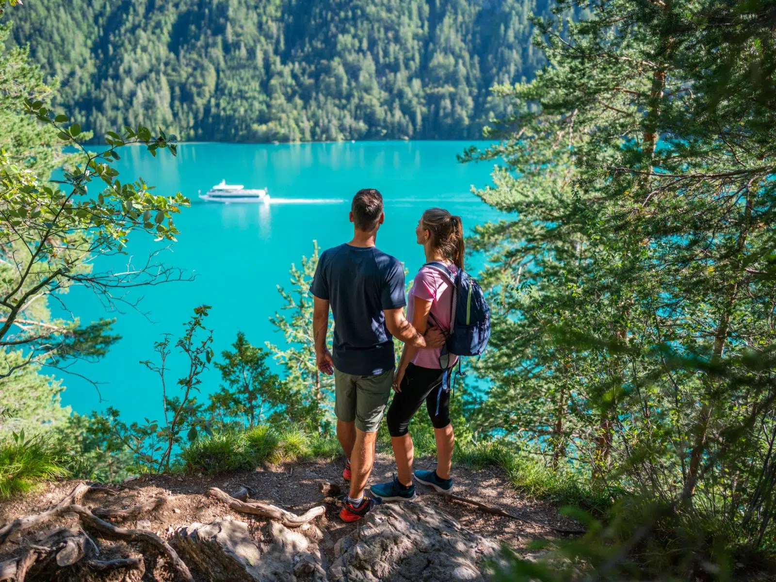 Ihr seht zwei Personen beim Wandern oberhalb des Weissensee in Kärnten.