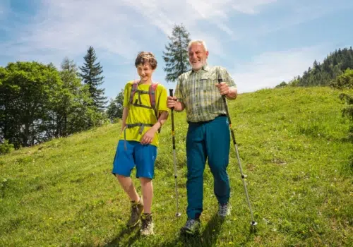 Ihr seht einen Großvater der mit seinem Enkel abwärts wandert.