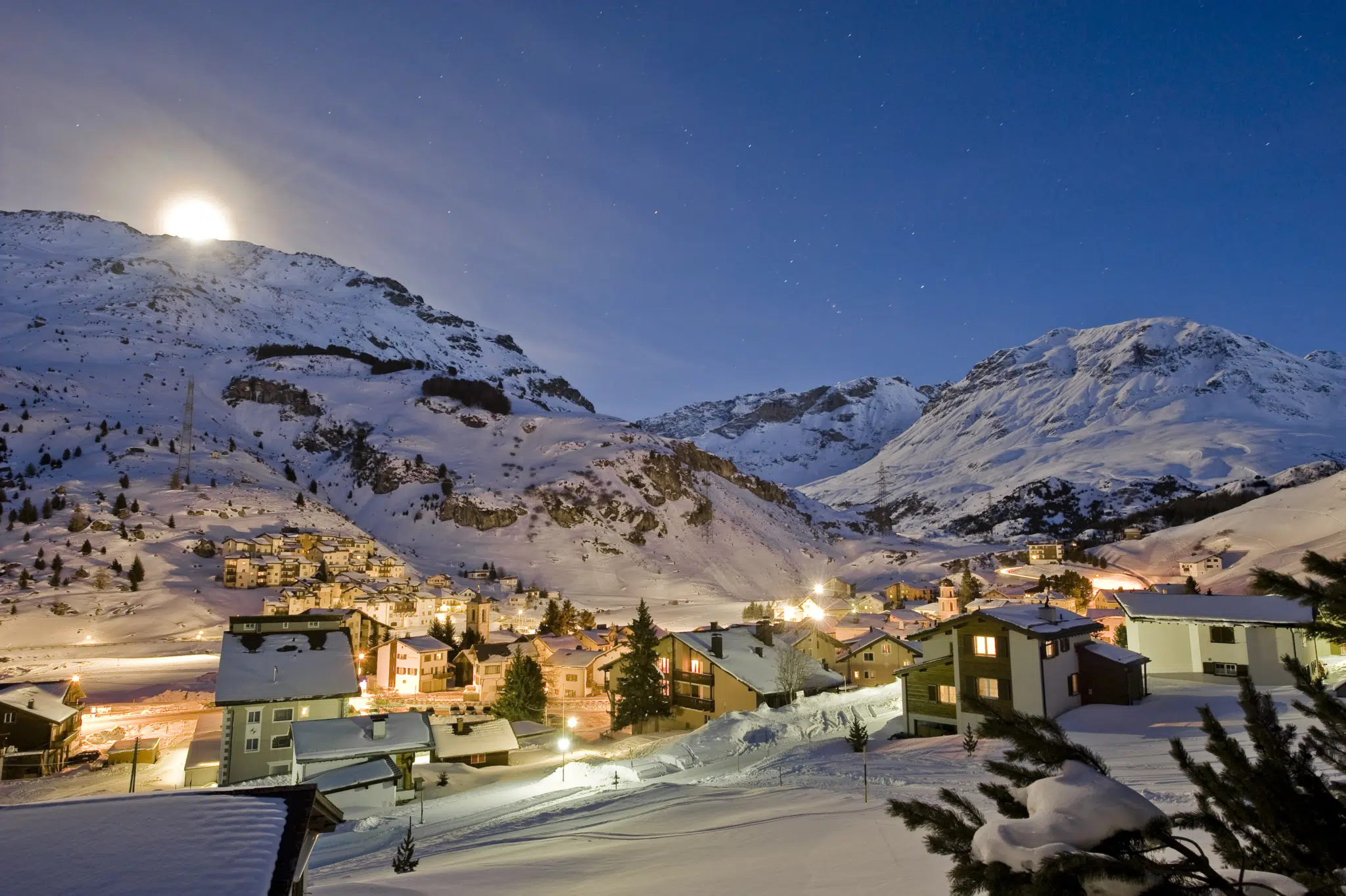 Ihr seht Savognin in Winterabendstimmung. JUFA Hotels bietet erholsamen Familienurlaub und einen unvergesslichen Winterurlaub.