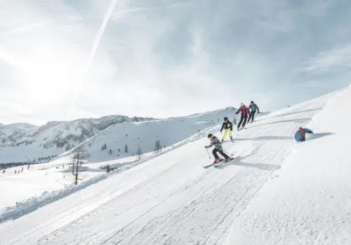 Ihr seht eine Gruppe von Personen beim Skifahren im Winter im Skigebiet Hinterstoder.