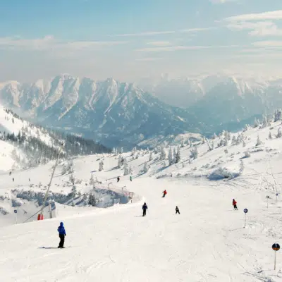 Skigebiet Hochkar im Mostviertel in Niederösterreich mit Skifahrern, die die Skipiste herunterfahren in der Nähe vom JUFA Hotel Hochkar. Der Ort für erfolgreiches Training in ungezwungener Atmosphäre für Vereine und Teams.