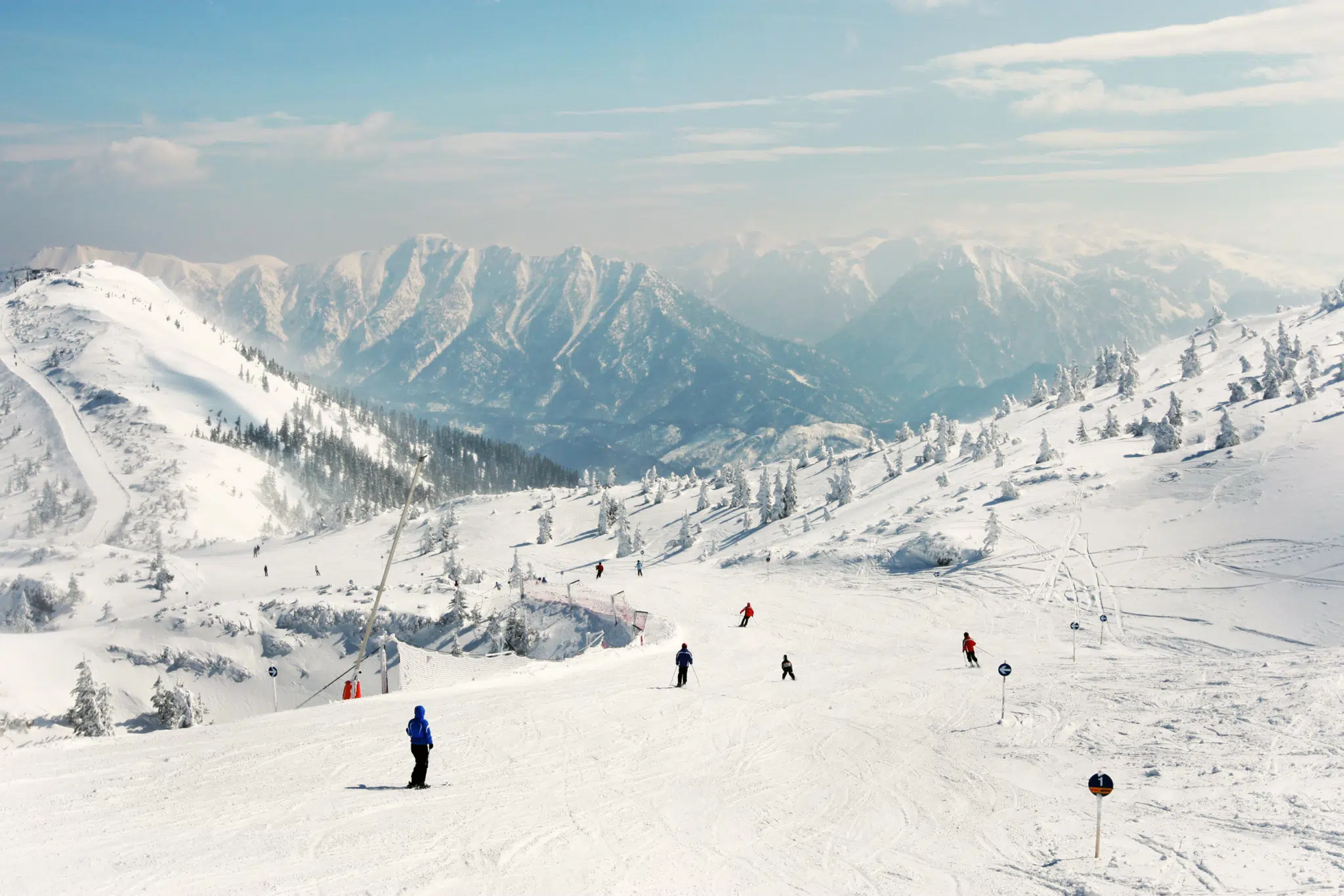 Skigebiet Hochkar im Mostviertel in Niederösterreich mit Skifahrern, die die Skipiste herunterfahren in der Nähe vom JUFA Hotel Hochkar. Der Ort für erfolgreiches Training in ungezwungener Atmosphäre für Vereine und Teams.