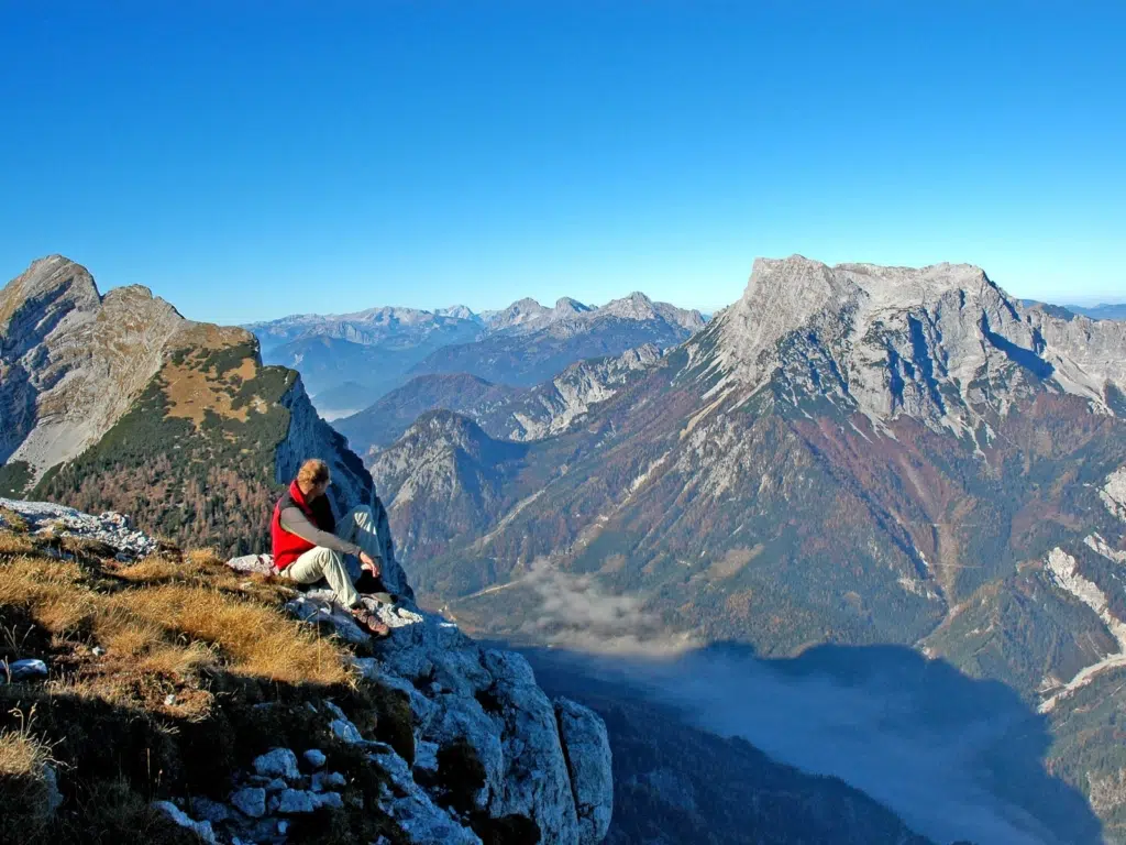 Mann macht eine Wandernpause und genießt herrlichen Ausblick im Nationalpark Gesäuse in der Steiermark.