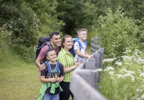 Ihr seht eine Familie beim Wandern, die die Aussicht genießt.