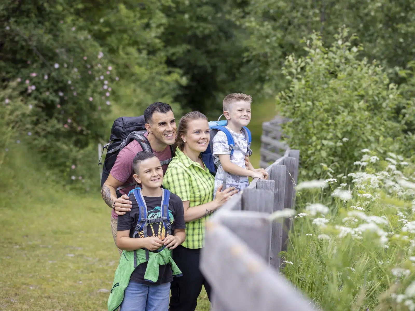 Ihr seht eine Familie beim Wandern, die die Aussicht genießt.