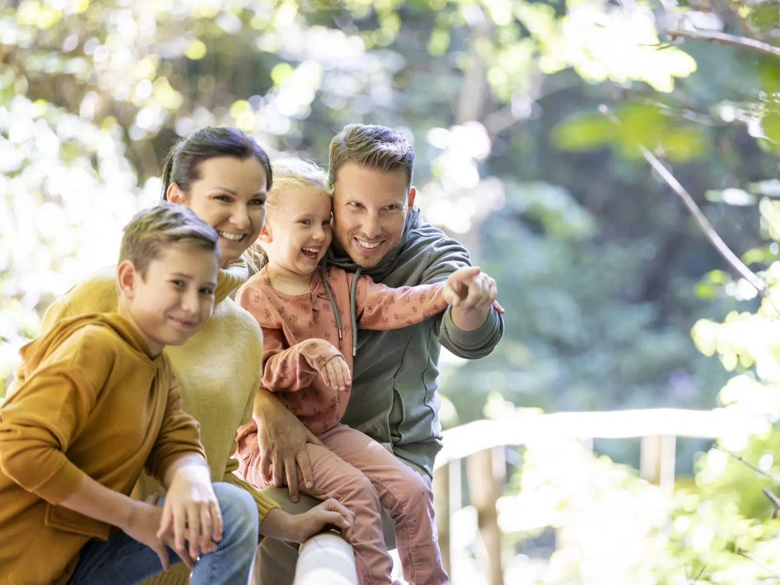 Ihr seht eine Familie, die gerade bei einem Herbstspaziergang pausiert und den Ausblick genießt.