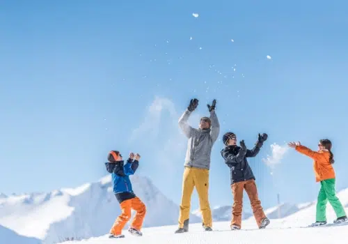 Ihr seht eine Familie im Schnee in Savognin. JUFA Hotels bietet erholsamen Familienurlaub und einen unvergesslichen Winterurlaub.