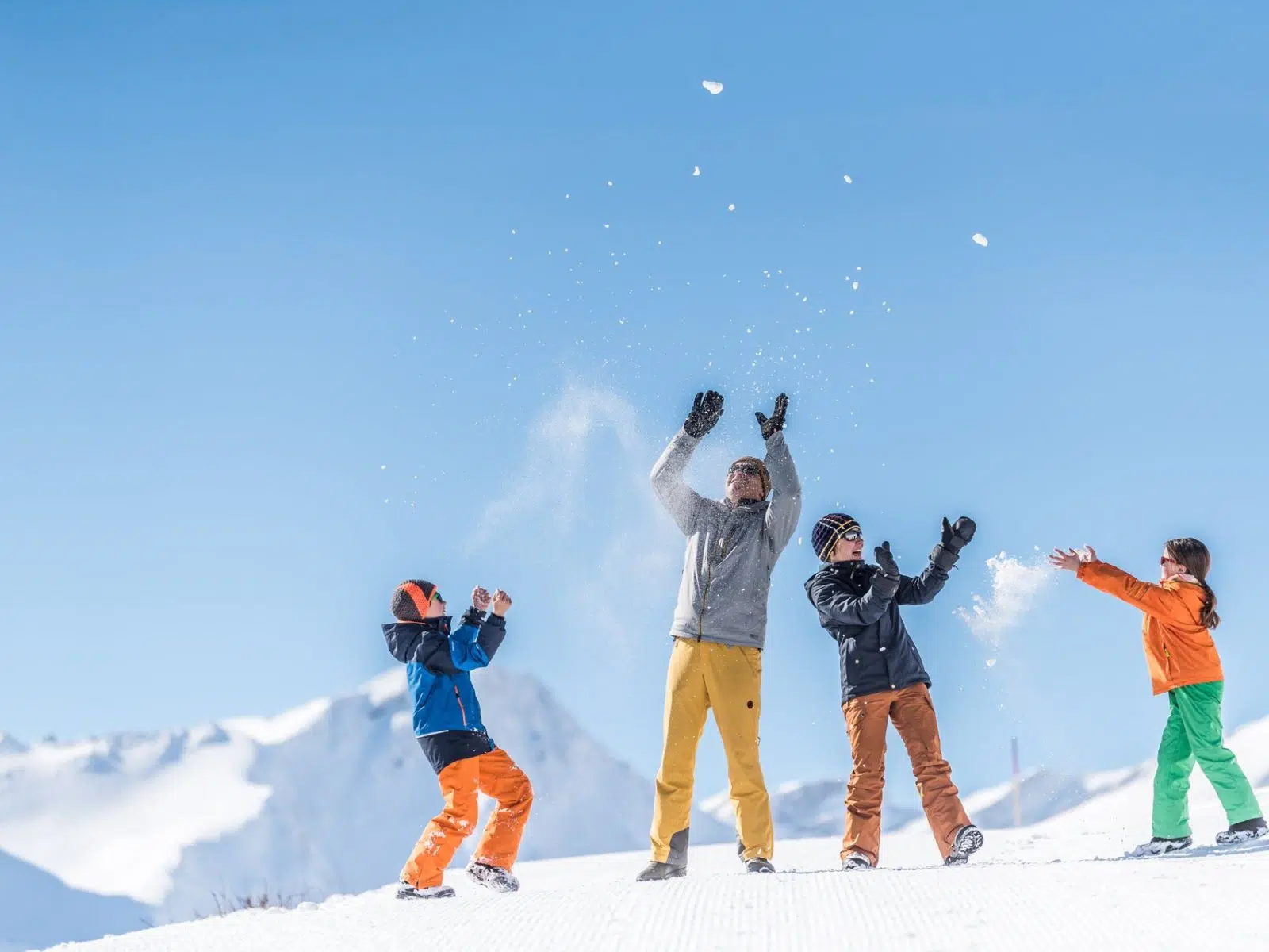 Ihr seht eine Familie im Schnee in Savognin. JUFA Hotels bietet erholsamen Familienurlaub und einen unvergesslichen Winterurlaub.