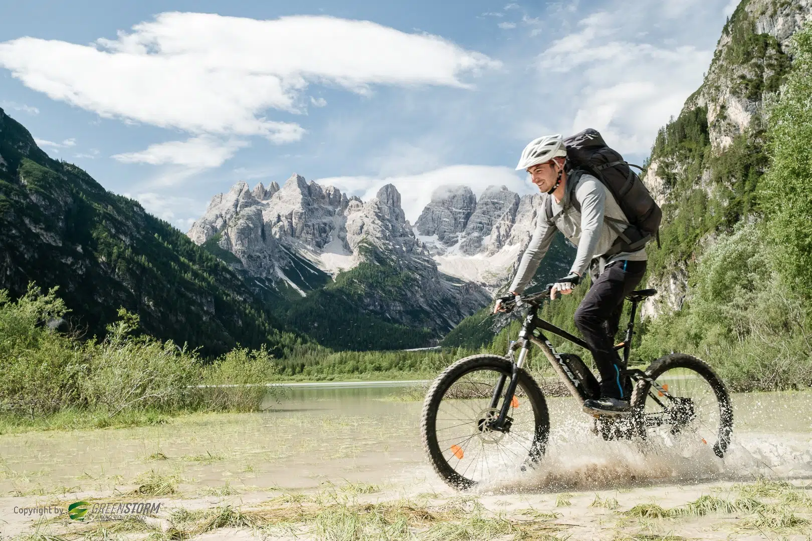 Ihr seht einen Mann mit E-Bike umgeben von Bergen.