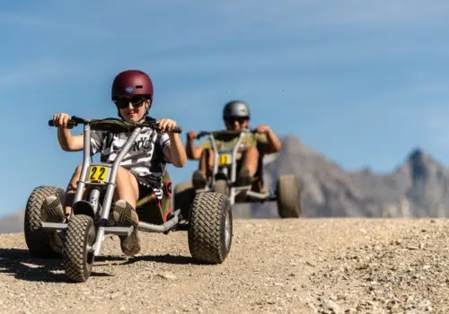 Ihr seht zwei Personen beim Mountainroller fahren in Savognin. JUFA Hotels bietet Ihnen den Ort für erlebnisreichen Natururlaub für die ganze Familie.