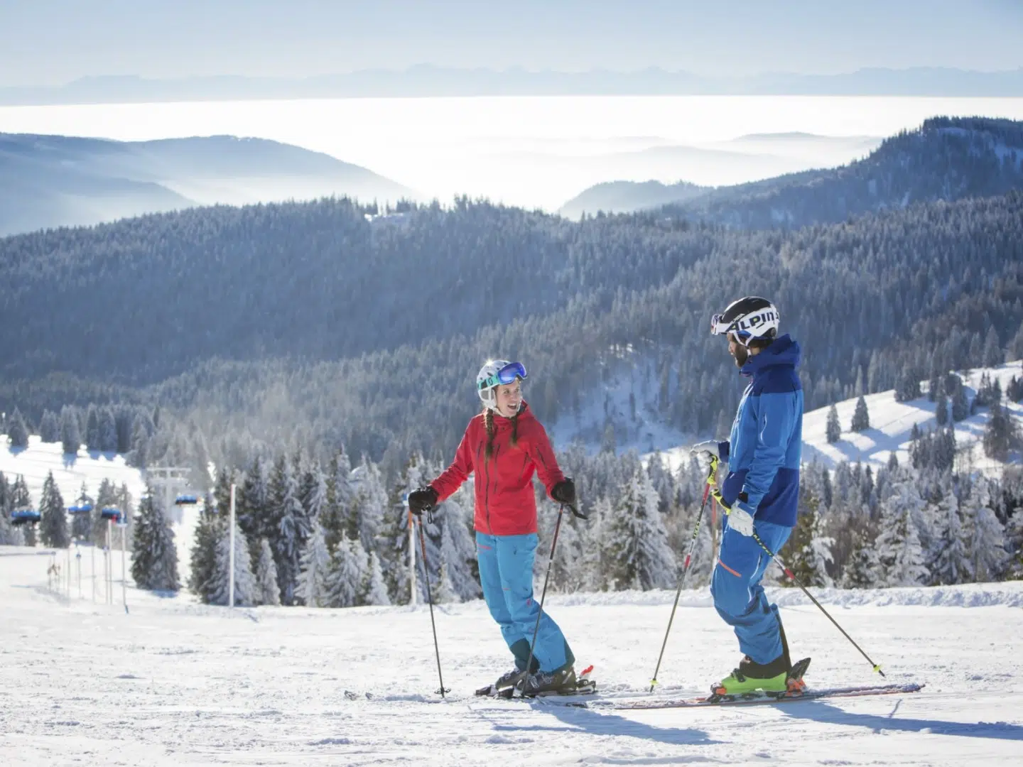 Ihr seht 2 Personen beim Skifahren am Feldberg im Schwarzwald.