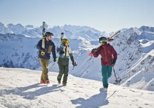 Ihr seht drei Personen mit Skiern im Winter in Saalbach-Hinterglemm.