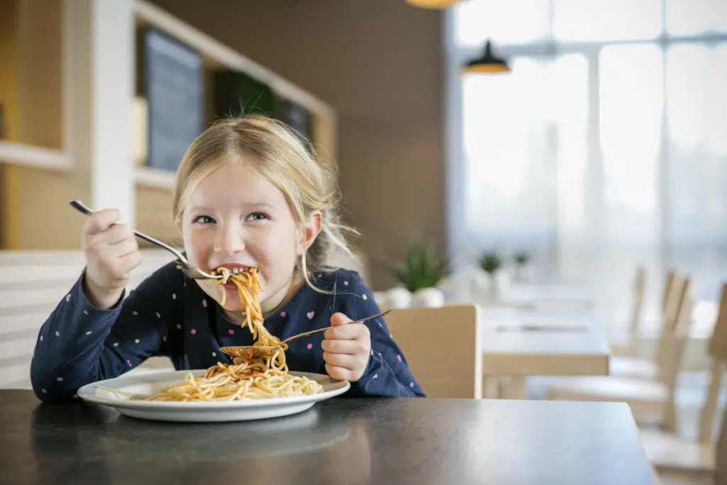 Ihr seht ein Mädchen beim Spaghetti-Essen im JUFA Hotel Graz City***. Der Ort für erlebnisreichen Städtetrip für die ganze Familie und der ideale Platz für Ihr Seminar.