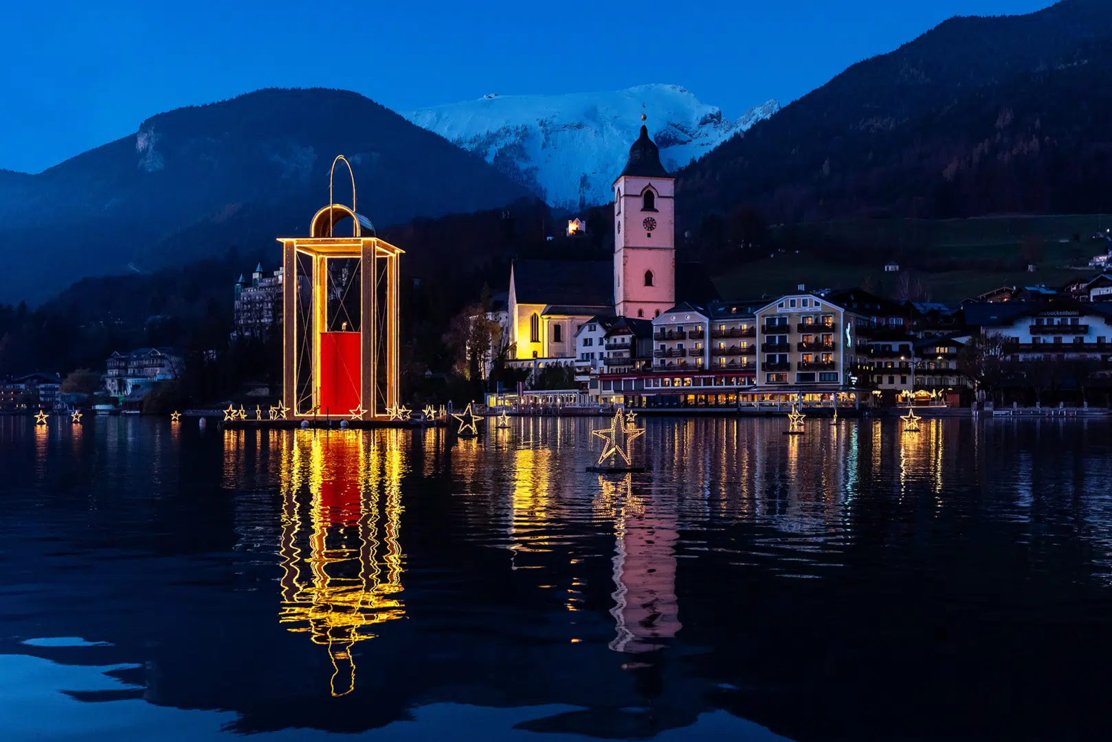 Ihr seht den Wolgangsee mit schwimmender Adventdekoration.