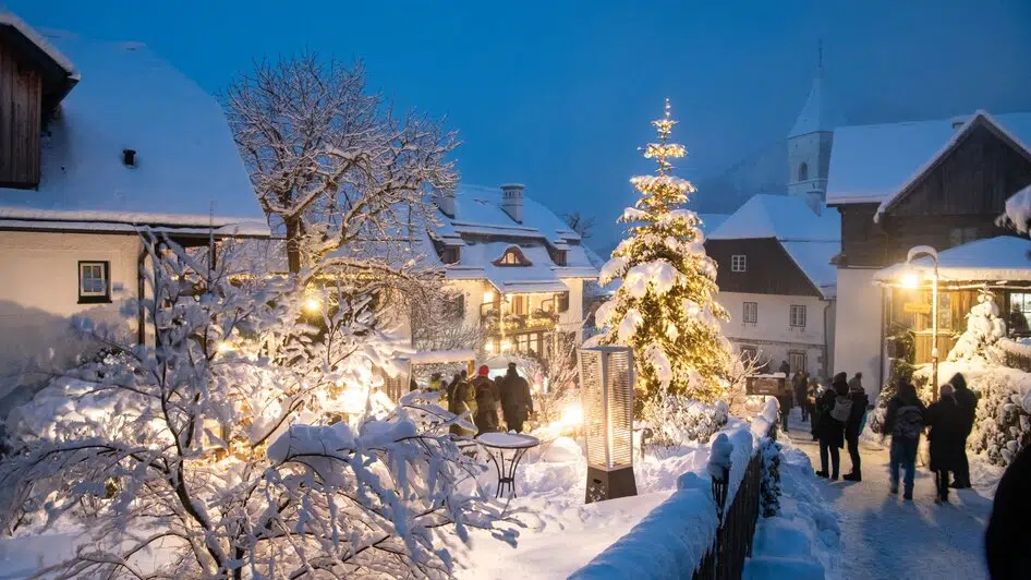 Ihr seht den Adventmarkt in Pürgg in schneebedeckter Landschaft.