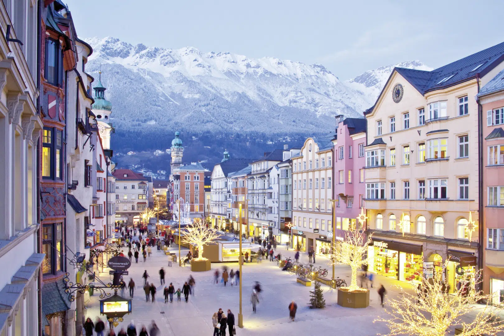 Ihr seht den Christkindlmarkt in Innsbruck mit Bergkulisse im Hintergrund. JUFA Hotels bietet erholsamen Familienurlaub und einen unvergesslichen Winter- und Wanderurlaub.