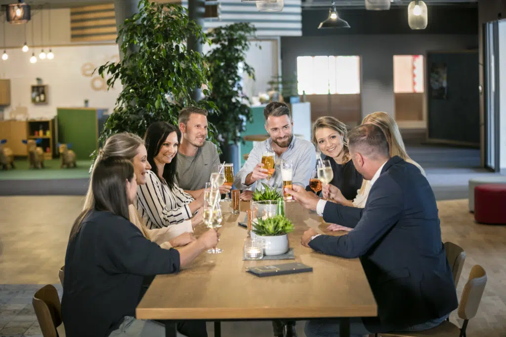 Ihr seht mehrere Personen bei einem Getränk im JUFA Hotel Weiz***s. Der Ort für erholsamen Familienurlaub und einen unvergesslichen Winter- und Wanderurlaub.