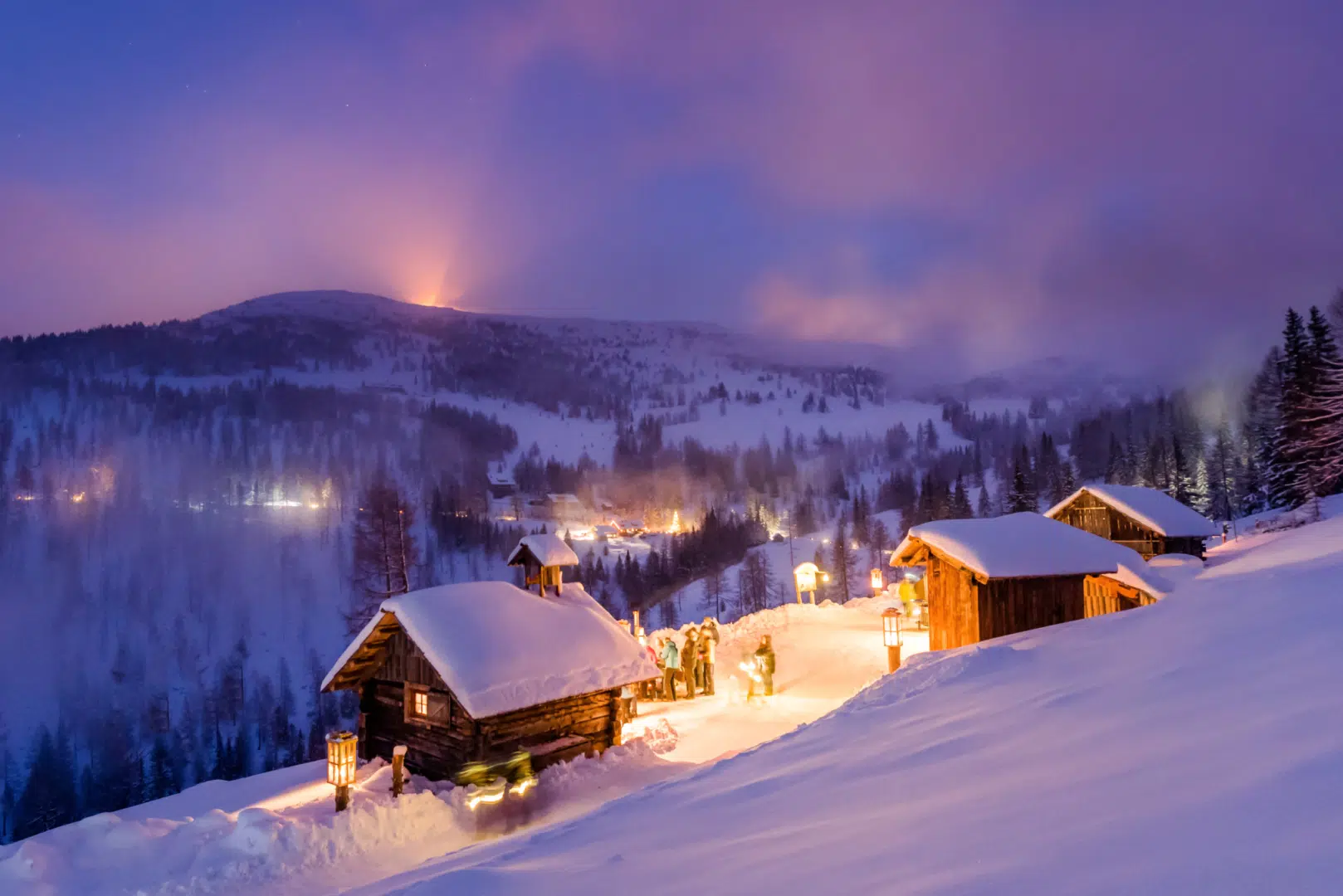 Ihr seht Hütten am Katschberger Adventweg am Abend. JUFA Hotels bietet erholsamen Familienurlaub und einen unvergesslichen Winterurlaub.